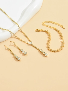 Detailed shot of golden necklace set with shimmering rhinestones on white decor