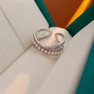 Elegant silver open ring with pearls and pavé zircon stones in a crisscross design