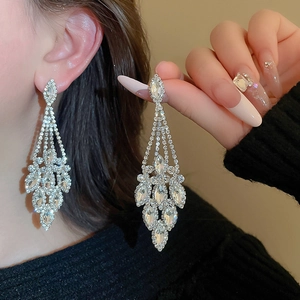 Dettaglio di orecchini pendenti in argento con strass a strati e cristalli marquise
