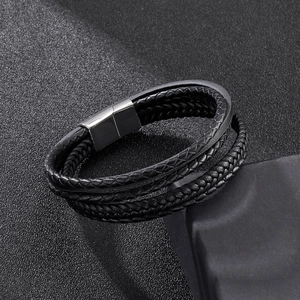 Macro view of multi-layer black braided leather bracelet with silver magnetic buckle