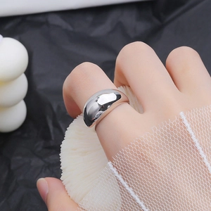 Close-up of wide polished silver titanium steel ring worn on model with mirror finish