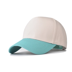 Detail of five-panel cotton baseball cap featuring beige crown and aqua blue brim
