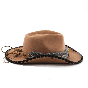 Detailed view of brown felt cowboy hat featuring ethnic pattern band and tassel accents