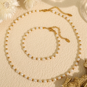 Baroque pearl necklace and bracelet set with gold beads on a beige textured background