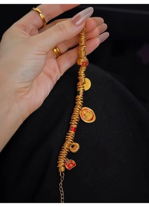 Detail of 24k gold plated bangle featuring zircon, enamel beads and lucky charms