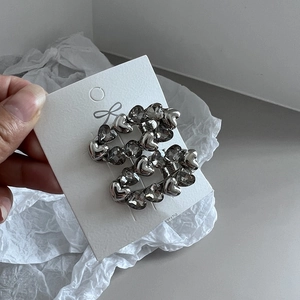 Detailed view of silver heart-shaped hair clip with dark rhinestones on a card
