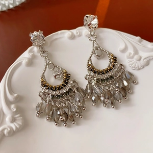 Détail macro de boucles d'oreilles pendantes avec perles grises sur plat vintage