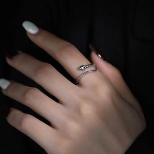 S925 sterling silver snake ring with green zircon eyes on a minimalist black background