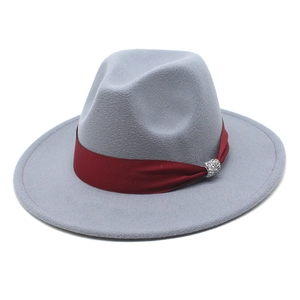 Detail of light gray wool fedora featuring a deep red ribbon and rhinestone silver buckle