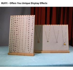Close-up of beige velvet necklace display boards with wooden base and serrated hooks