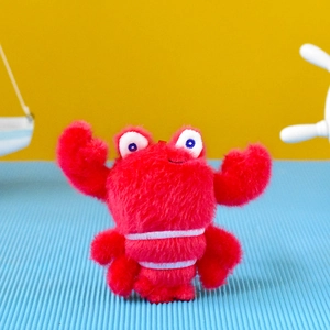 Detail view of a cute red plush lobster toy with soft fuzzy texture and googly eyes