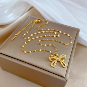 Close-up of golden butterfly pendant with sparkling cubic zirconia on a silk background
