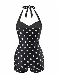 Detail of vintage black polka dot one-piece swimsuit with halter neck and boyleg design