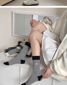 Detailaufnahme von Damen-Baumwollsocken mit Streifenmuster und kleiner Bärenstickerei