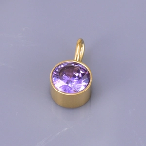 Detailed macro view of a gold-plated birthstone pendant with a round purple gemstone