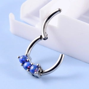 Detailed macro view of silver steel hoop jewelry featuring three inlaid blue opal stones