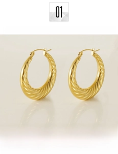 Macro detail of 18K gold plated titanium steel twisted hoop earrings with polished finish