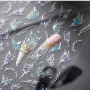 Macro detail of 3D aurora butterfly nail stickers with pearls and cursive text on nails