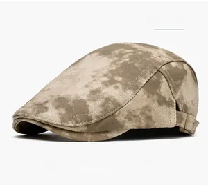 Detail of khaki tie-dye flat cap featuring an adjustable metal buckle and canvas texture