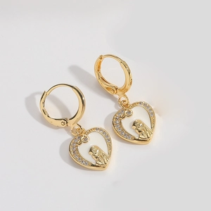 Close-up of gold heart earrings with white enamel relief and sparkling zircon border