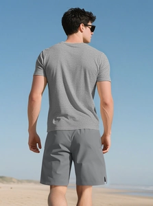 Rear view of men's grey slim fit athletic t-shirt and shorts set on a sunny beach