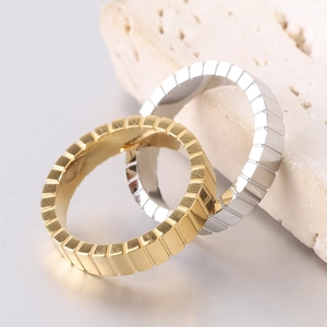 Macro shot of 4mm gold and silver industrial grooved stainless steel rings on stone base