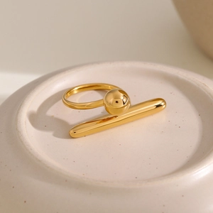 Detailaufnahme eines geometrischen Rings aus 18k vergoldetem Edelstahl auf einem Tablett