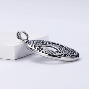 Silver stainless steel tree of life pendant on a white geometric display stand