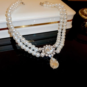 Macro shot of double-layered pearl necklace with crystal pendant and gold plating