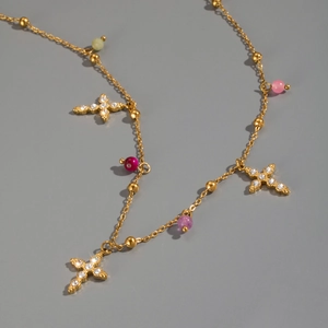 Detailed macro view of 18K gold stainless steel cross necklace with colorful beads
