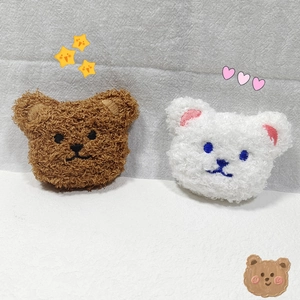 Close-up of cute plush cartoon bear heads in brown and white for clothes decoration