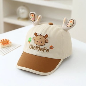 Détail de la casquette bébé avec décorations en peluche et broderie girafe
