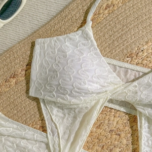 Nahaufnahme eines weißen Bikinisets mit 3D-Wellenstruktur und Neckholder-Top
