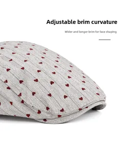 Detail of grey herringbone fabric with red heart embroidery and foldable wide visor