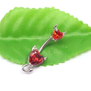 Vue macro du piercing de nombril diable en argent avec zircons rouges en cœur