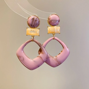 Detail of vintage marble pattern geometric earrings with purple and beige resin charms