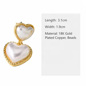 Detalle de pendientes de doble corazón y perlas en cobre bañado en oro de 18K, 3,1x1,9 cm