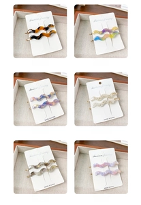 Macro shot of wavy acetate hair clips in multiple colors on branded display cards