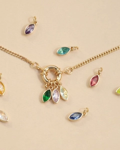 Close-up of 18K gold plated oval birthstone pendants with colorful zirconia crystals