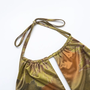 Detailed view of backless halter dress with olive green floral print on glossy satin fabric