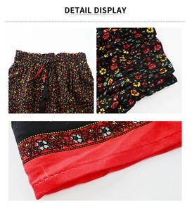 Détail de la taille élastique avec cordon à pompon et ourlet à motif floral sur la jupe