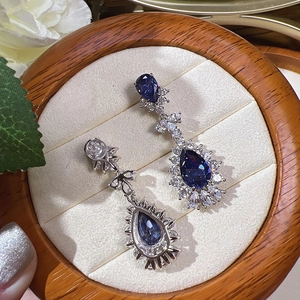 Detailed view of luxury blue teardrop earrings with crystals in a wooden jewelry box