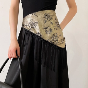 Detail of vintage floral jacquard waist belt with elegant black fringe tassels on satin