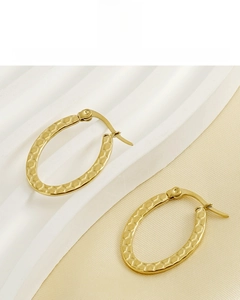 Detail of gold oval earrings with honeycomb texture and 18K vacuum plating finish