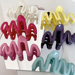 Collection of wave-shaped cream hair claws in various vibrant colors with glossy finish