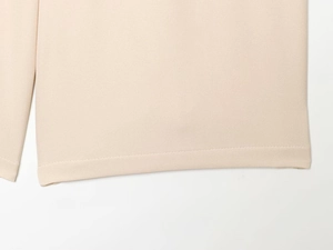 Gros plan sur la texture du tissu en sergé beige et les coutures du short décontracté