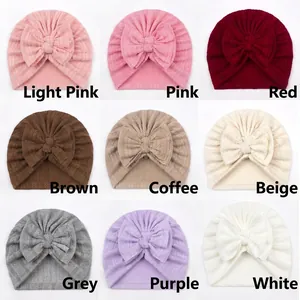 Detail view of baby turban hats showing chevron knit texture in nine different color options