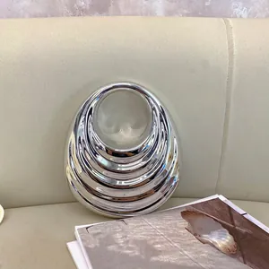Elegant gold acrylic textured handbag with a unique silver mirrored circular design