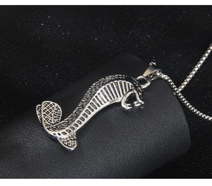 Détail du pendentif cobra en argent avec écailles ciselées sur cuir noir texturé