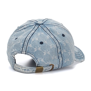 Detail of light blue denim baseball hat featuring star patterns and bronze metal buckle